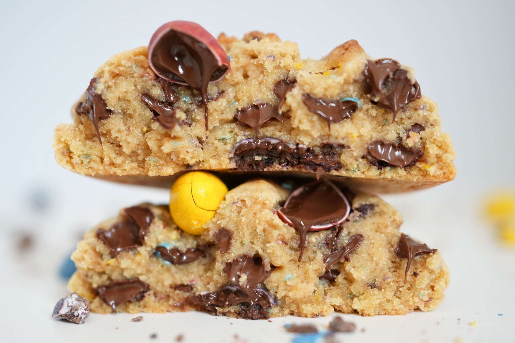 giant bakery style cookie broken in half showing gooey chocolate and melty mini cadbury eggs.